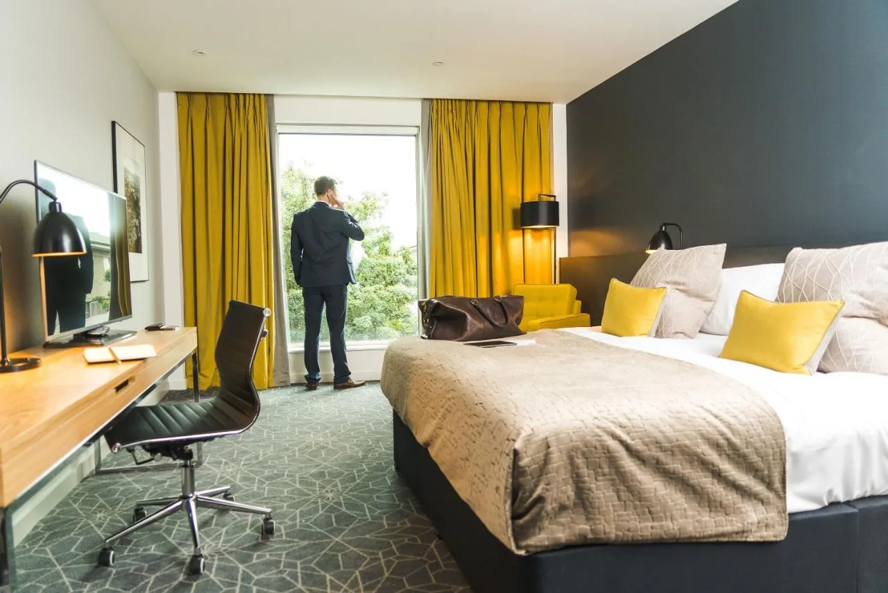 a man standing in a hotel room looking out the window at Apex City of Bath Hotel in Bath