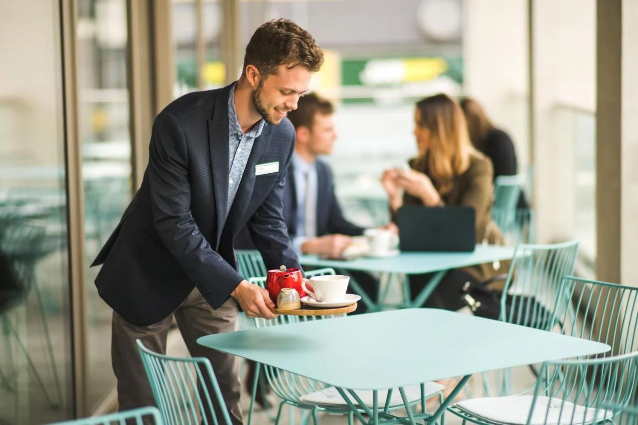 a man standing at a table with a plate of food at Apex City of Bath Hotel in Bath